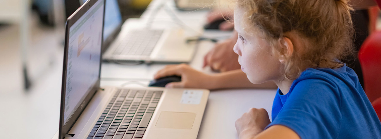 Children working on laptops in a classroom