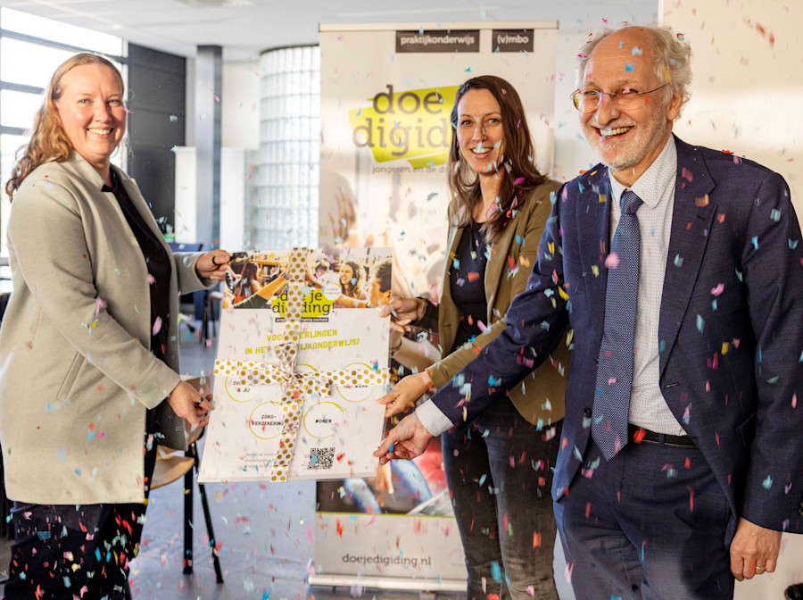 Piet Boekhoudt (director of the Digisterker Foundation) hands over the teaching material of the teaching program 'Doe je Digiding!' to Noortje van den Boogaard (director of practical training school de Rijzert) and Jamie Visser (Secretary of the Practical Education Sector Council).