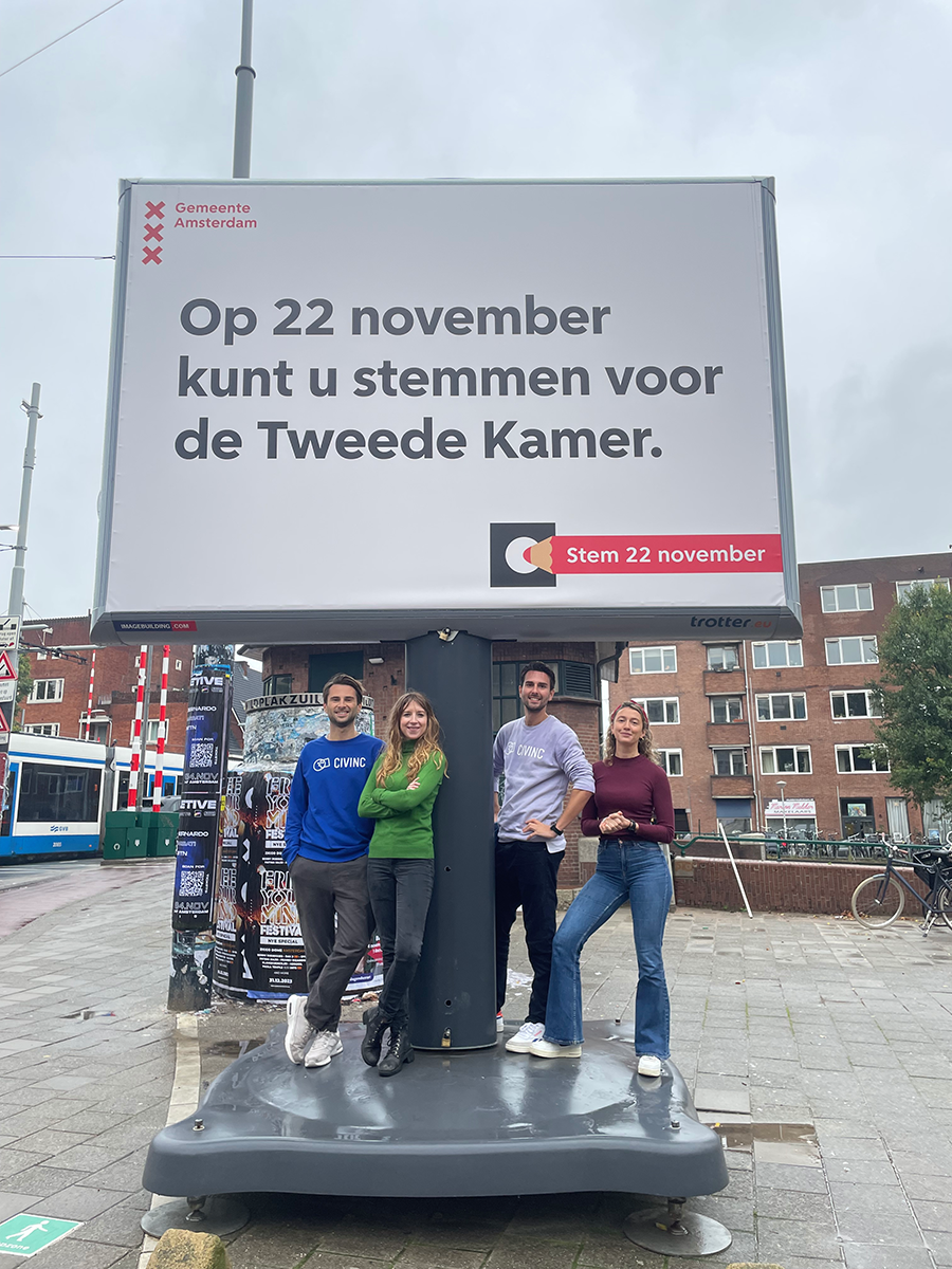 The 'Waaromkiesjij.nl' ('Why choose you') team under a billboard calling for the House of Representatives elections on 22-11-23.