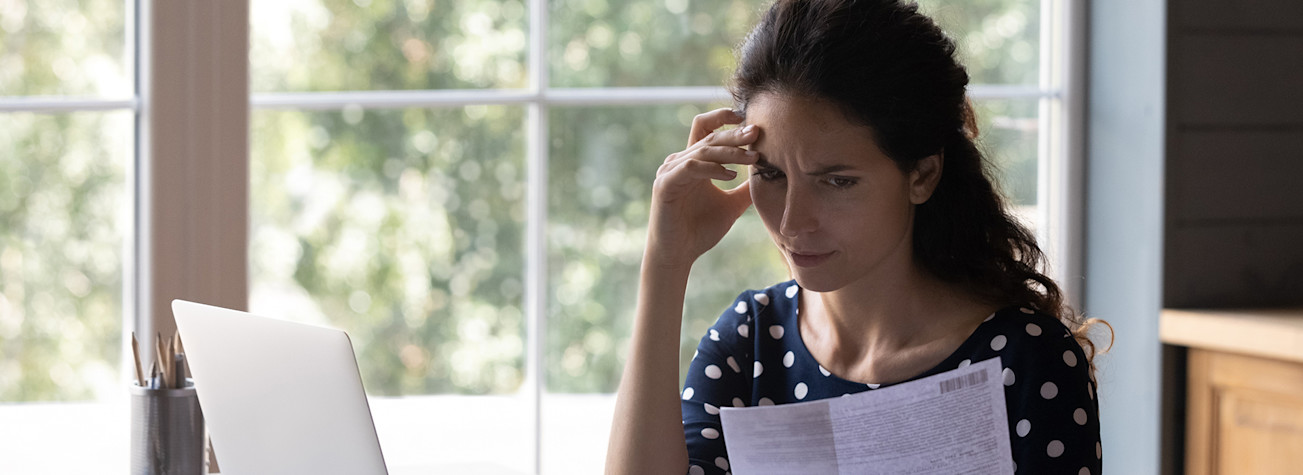 Vrouw kijkt fronsent naar factuur