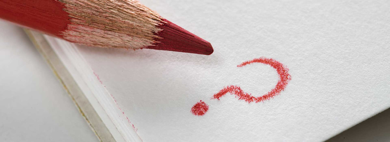 Close-up of a red pencil and written question mark