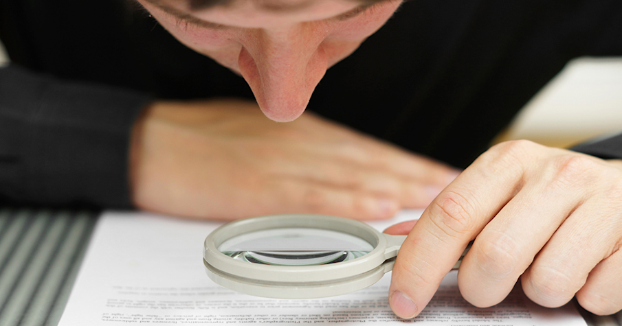 Man looking through a magnifying glass terms and conditions