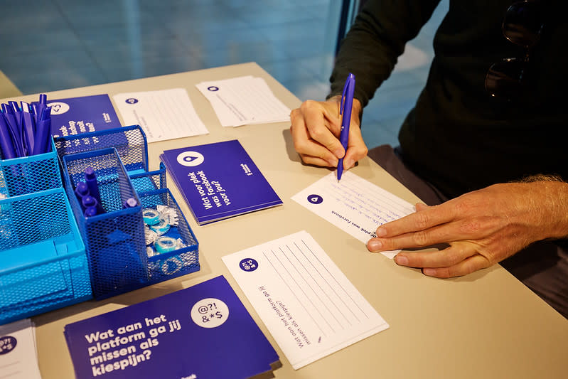 Iemand vult een herinneringskaartje in in het Facebook Museum op station Utrecht Centraal 