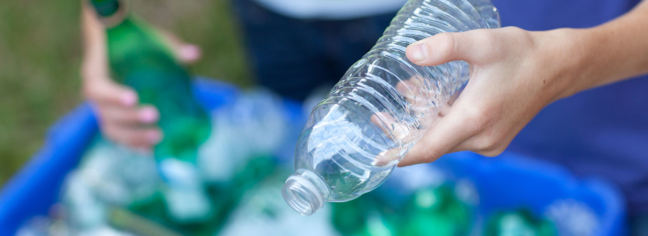 Hands throwing plastic bottles in the trash