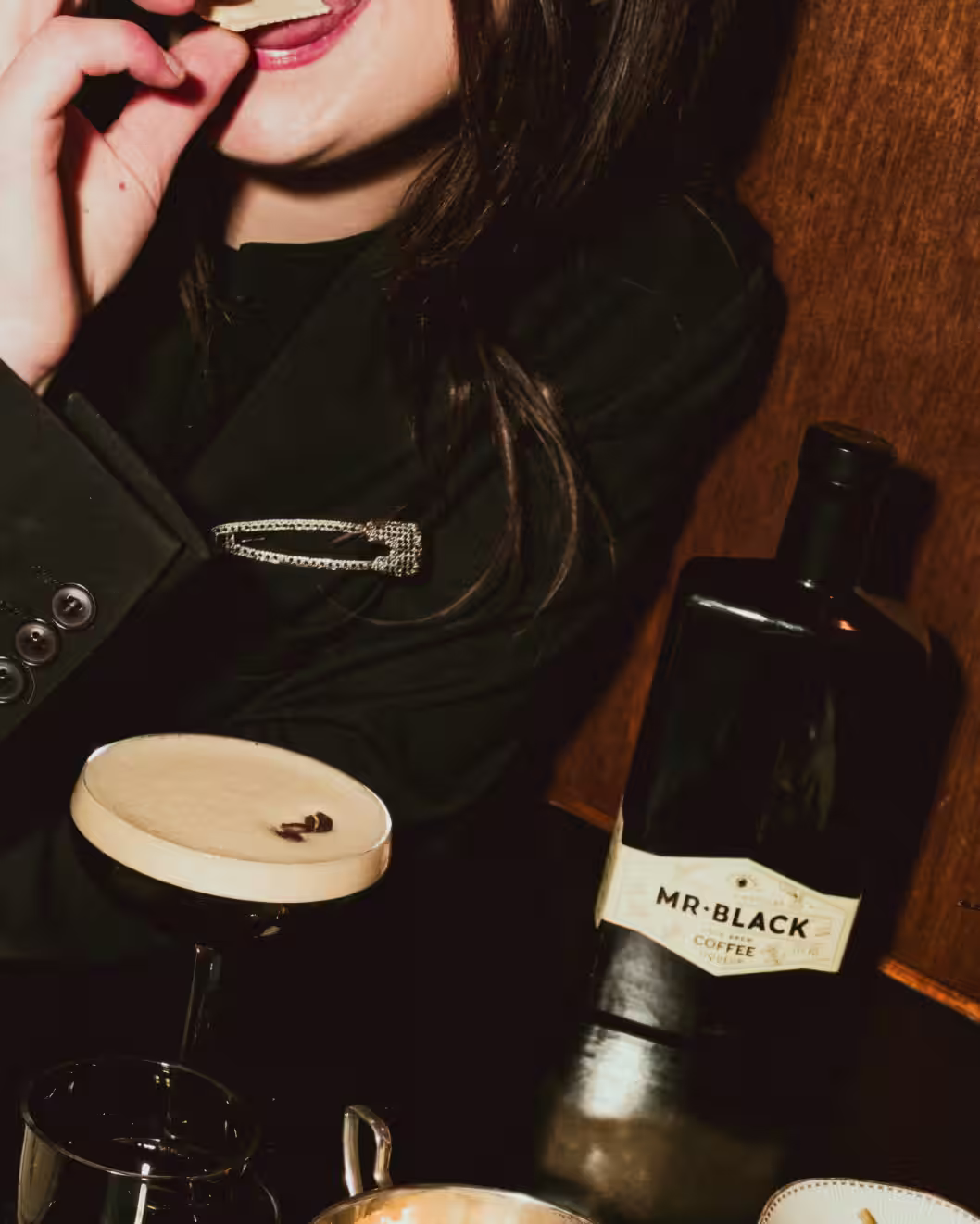 Woman enjoying a Mr Black Espresso Martini with a Mr Black Bottle