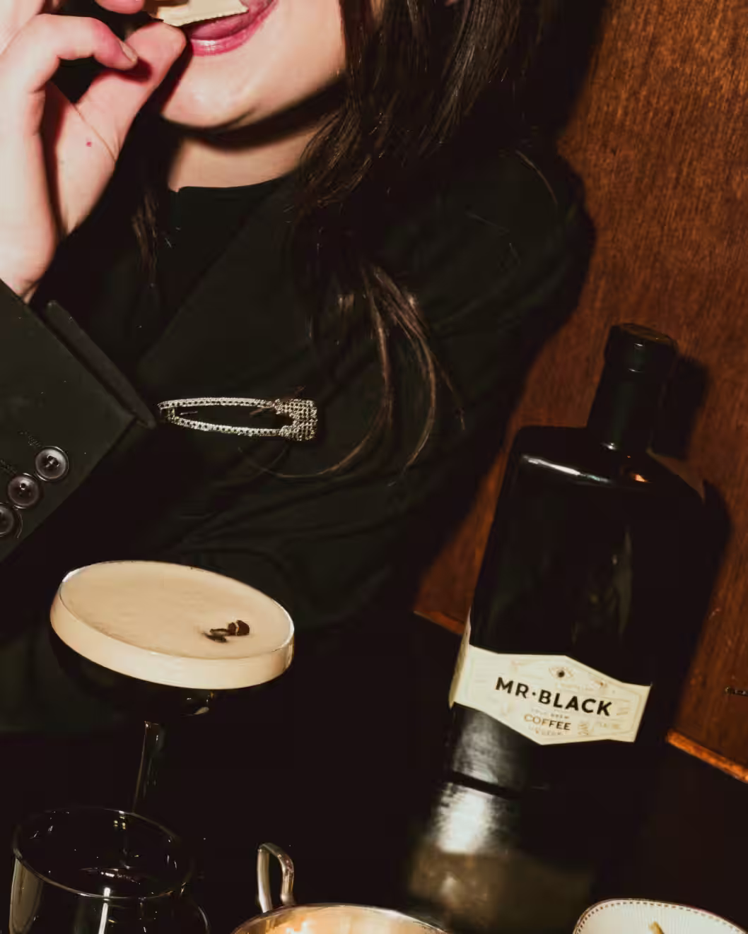 Woman enjoying a Mr Black Espresso Martini with a Mr Black Bottle