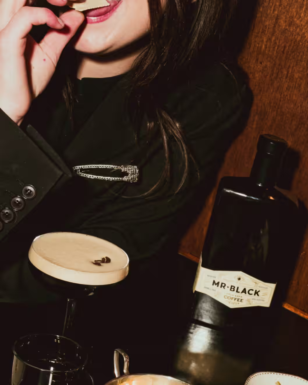 Woman enjoying a Mr Black Espresso Martini with a Mr Black Bottle