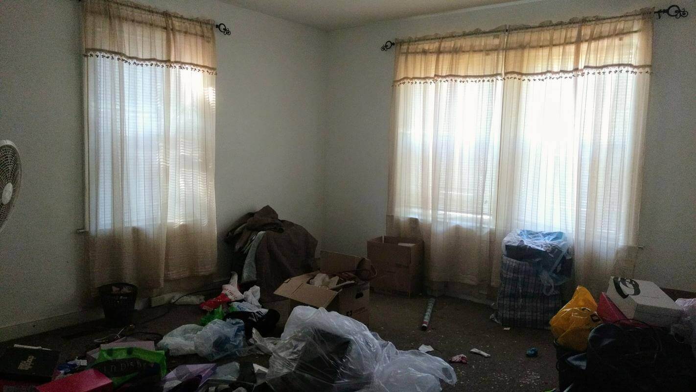 The bedroom pre-renovation with stuff strewn about