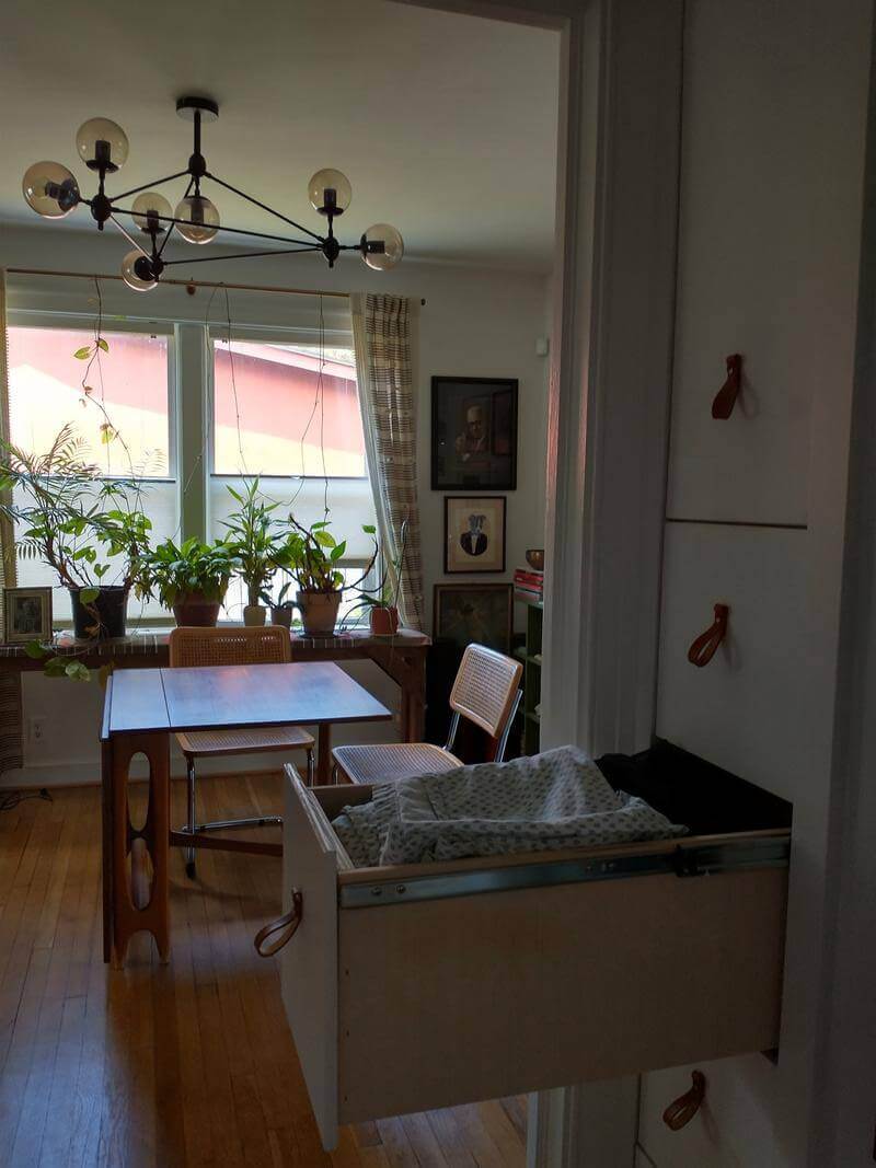 A view of the dining room from the hallway, with modern, space-saving storage in the foreground.