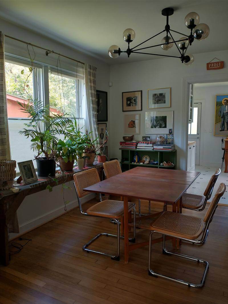 A bright dining room featuring a wooden table with cantilever chairs and modern lighting