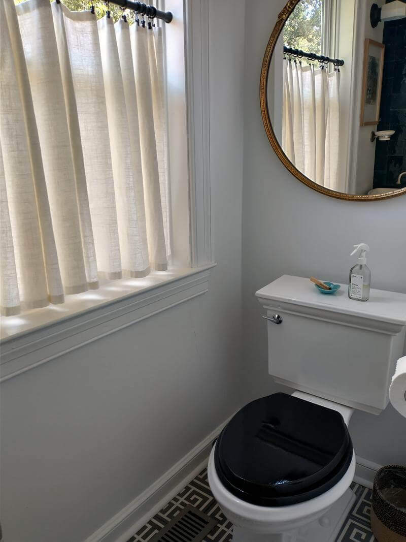 A half bathroom with dark tile, and low light