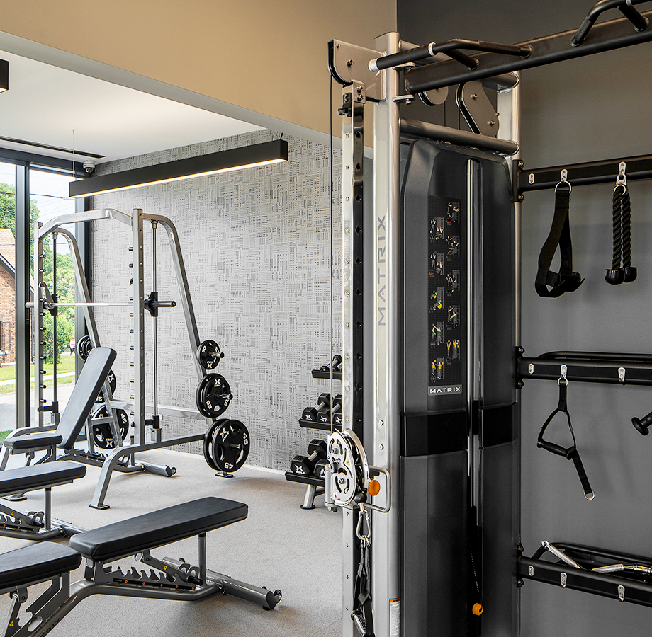 Gym with cardio and strength training equipment, a yoga studio, and large windows for ample natural light.
