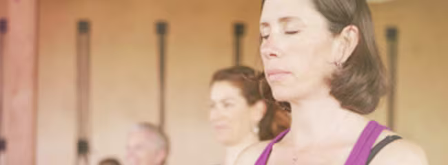 Persoane însărcinate stând cu ochii închiși în timpul unei ședințe de yoga prenatală