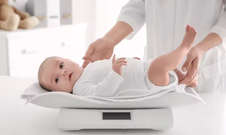 Baby wird in Kinderarztpraxis gewogen
