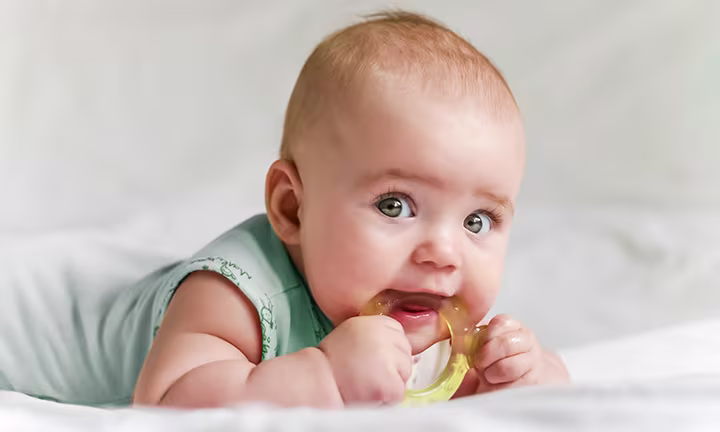 Baby mit Beißring im Mund