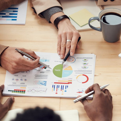 Zespół agentów nieruchomości omawiający strategię marketingową przy tablicy