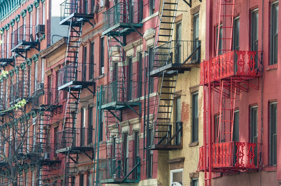East Village apartment facades with colorful brickwork and prominent metal fire escapes.