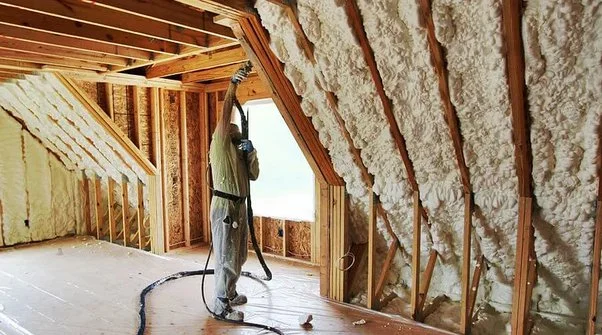 worker is doing insulation in room