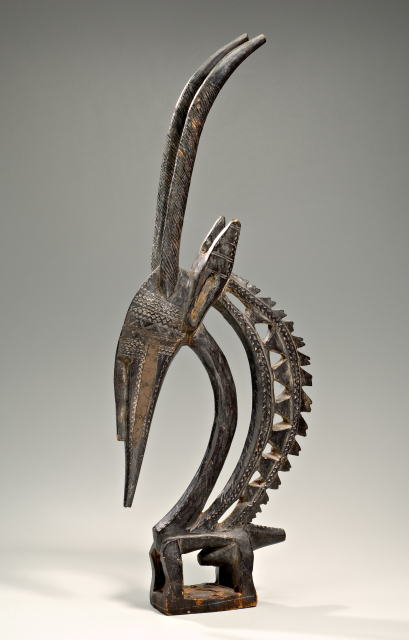 Antelope headdress with long curving horns. The headdress contains a lot of openwork and fine detailed carving.
