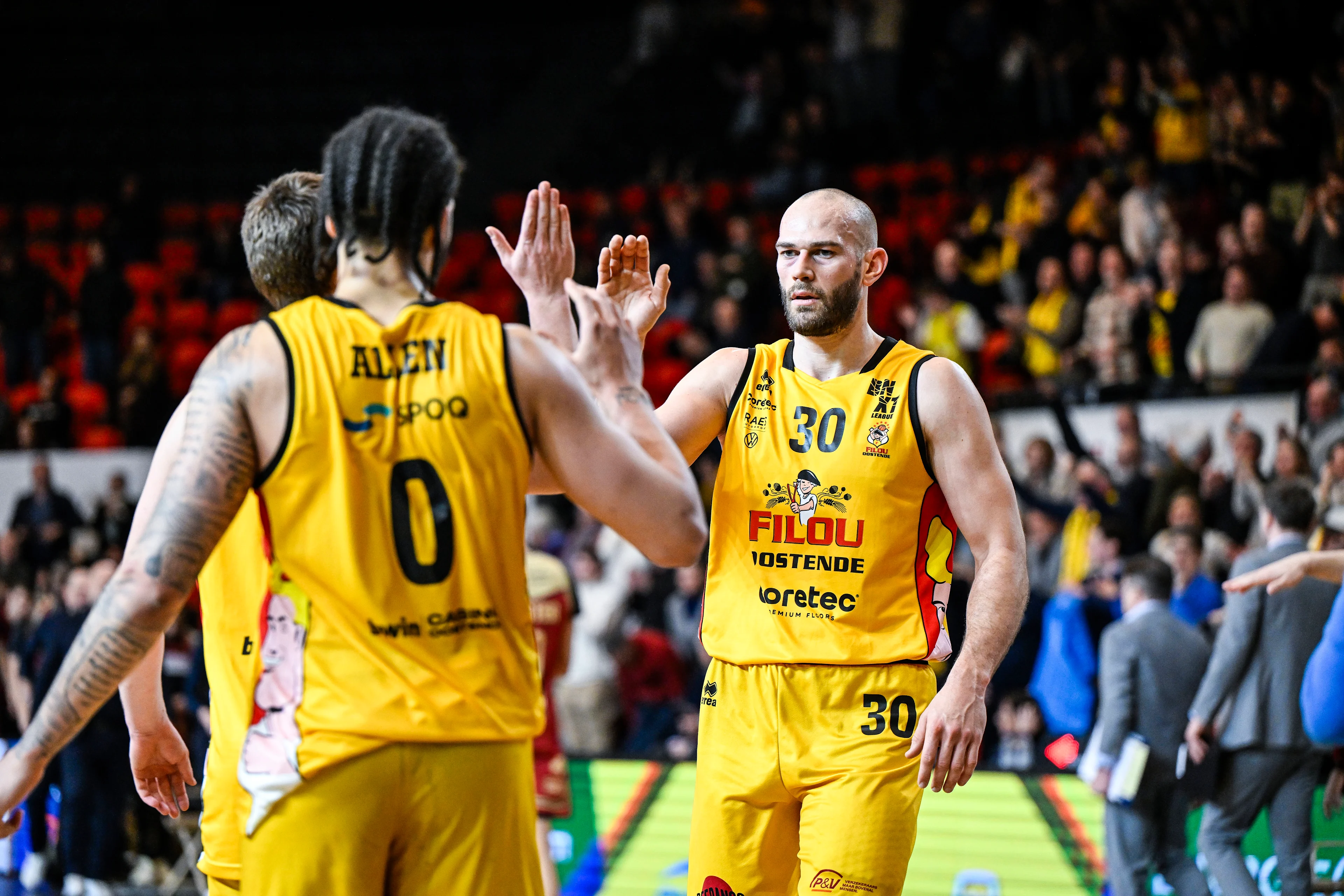 Oostende's Timmy Allen and Oostende's Pierre-Antoine Gillet celebrate after winning a basketball match between Filou Oostende and Antwerp Giants, Thursday 13 February 2025 in Oostende, the return leg of the semi-finals of the men's Belgian Basketball Cup. BELGA PHOTO TOM GOYVAERTS