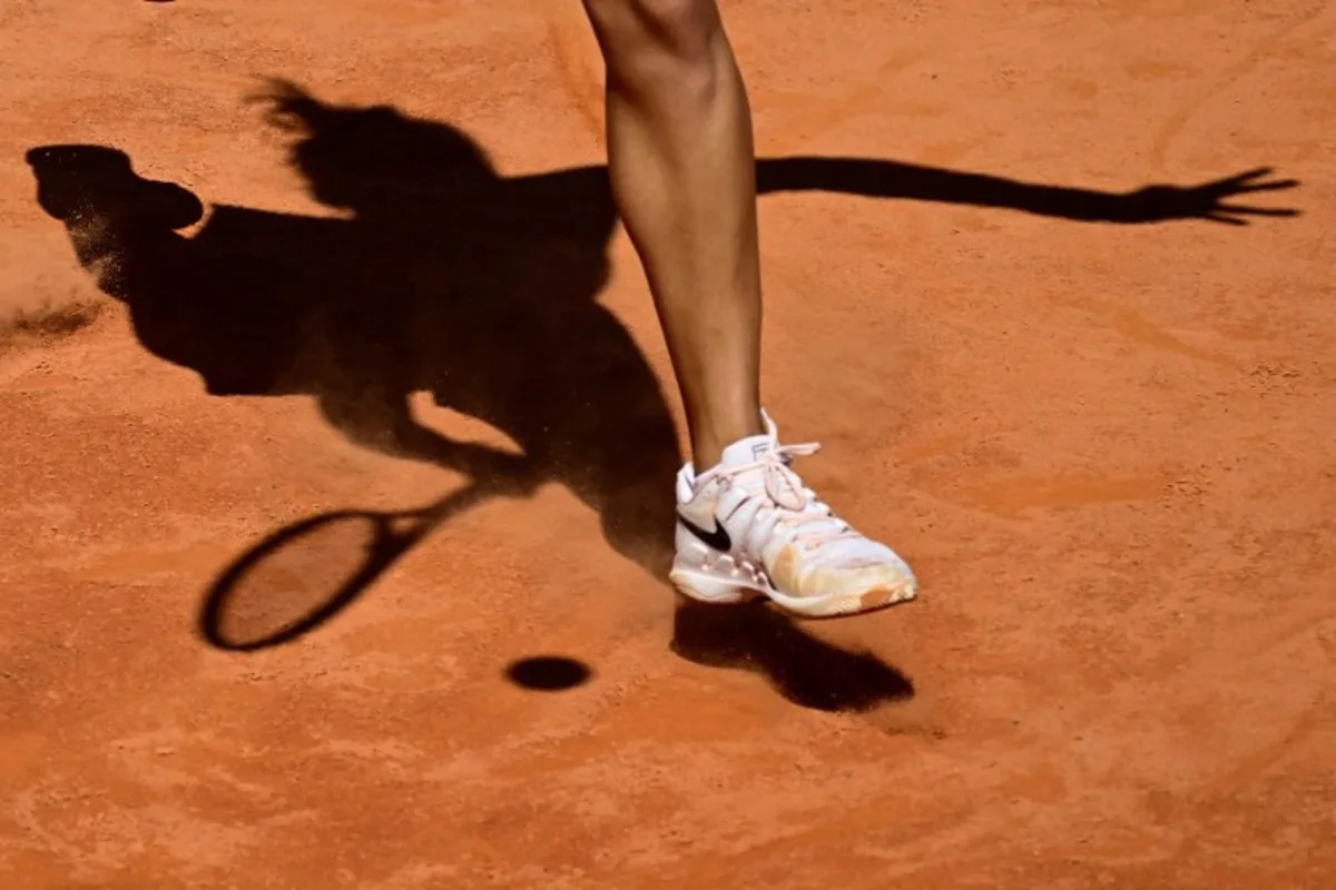 Picture of the shadow of China's Qinwen Zheng during her match against Czech Republic's Linda Noskova at the Women's WTA Rome Open tennis tournament at Foro Italico in Rome on May 11, 2024.   Tiziana FABI / AFP