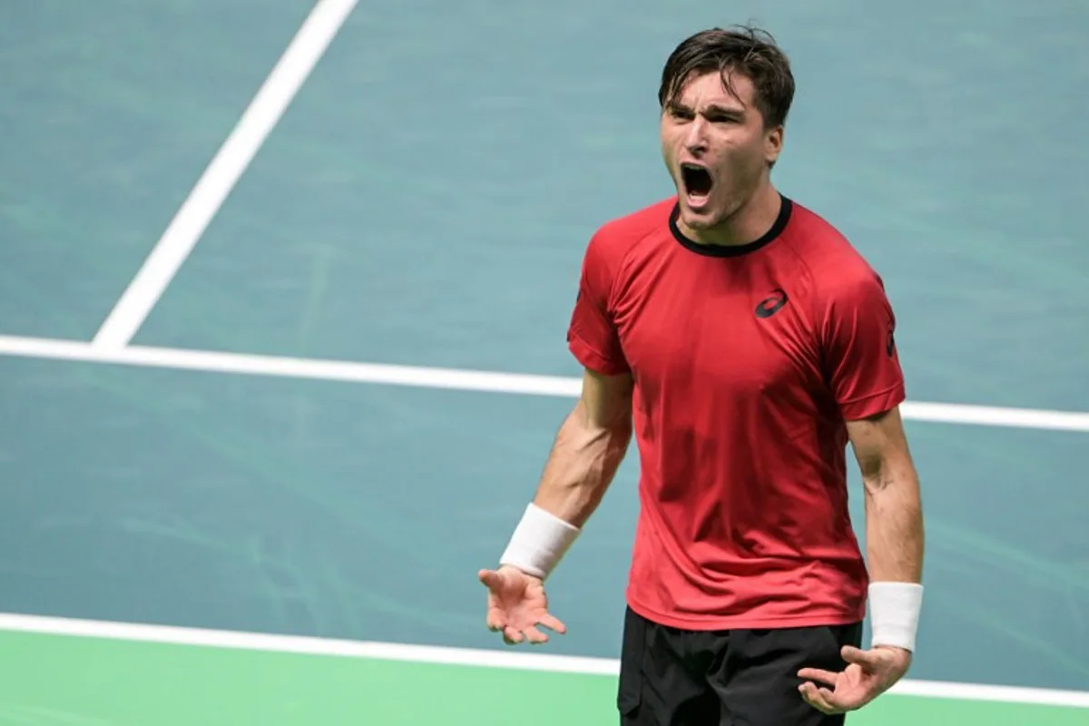 Belgium's Raphael Collignon celebrates after winning against France's Corentin Moutet during their Davis Cup men's singles quarter finals tennis match, at the Super Tennis Arena, in Bologna, northen Italy, on November 18, 2025.  Tiziana FABI / AFP