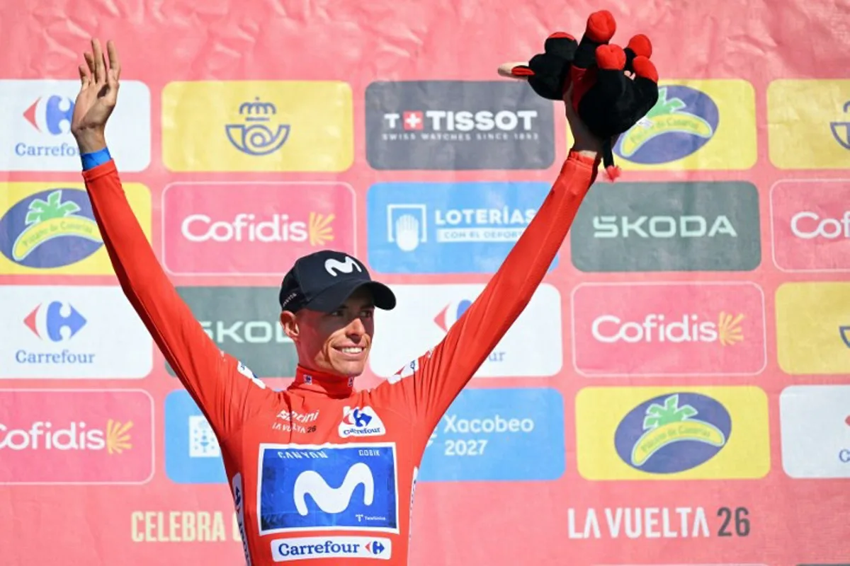 Overall leader Team Movistar's Spanish rider Enric Mas celebrates on the podium retaining the red jersey after the 20th stage of the Vuelta a Espana 2026 cycling tour, a 186,8 km race between La Calahorra and Collado del Alguacil, on September 12, 2026.  Home favourite Enric Mas moved to the brink of Vuelta a Espana victory today as he finished the 20th and penultimate stage by extending his lead on Primoz Roglic in the overall standings. JORGE GUERRERO / AFP