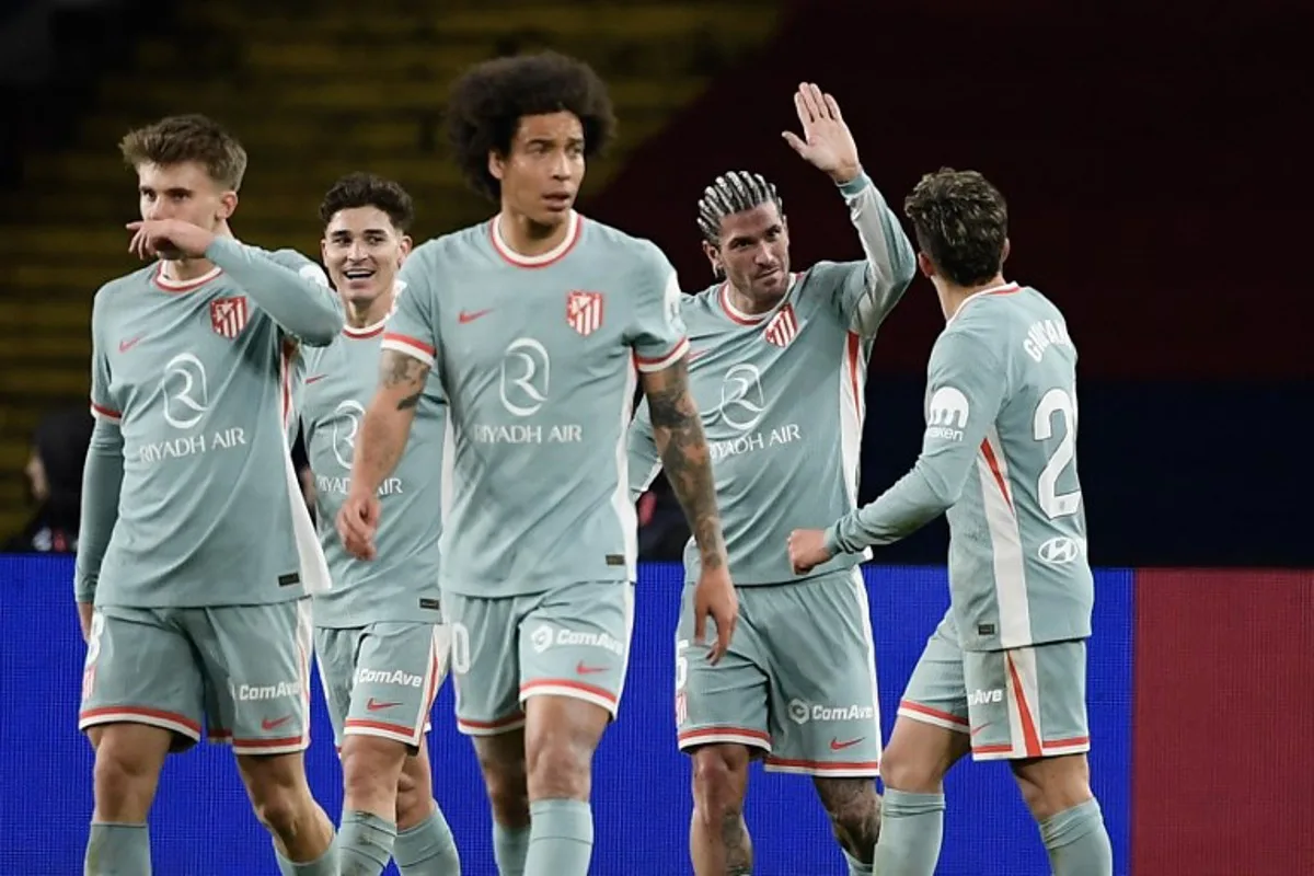 Atletico Madrid's Argentine midfielder #05 Rodrigo De Paul (2R) celebrates scoring their first goal during the Spanish league football match between FC Barcelona and Club Atletico de Madrid at the Estadi Olimpic Lluis Companys in Barcelona on December 21, 2024.  Josep LAGO / AFP