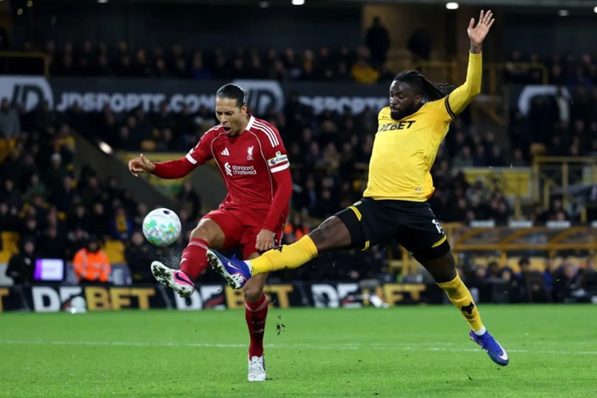 Liverpool's Dutch defender #04 Virgil van Dijk battles for possession with Wolverhampton Wanderers' Nigerian striker #14 Tolu Arokodare during the English Premier League football match between Wolverhampton Wanderers and Liverpool at the Molineux stadium in Wolverhampton, central England on March 3, 2026. Darren Staples / AFP