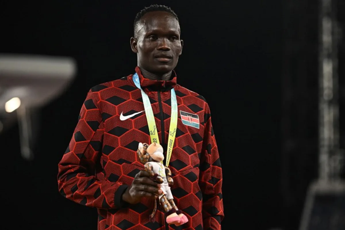 Bronze medallist Kenya's Kibiwott Kandie celebrates on the podium during the medal ceremony for the men's 10,000m athletics event at the Alexander Stadium, in Birmingham on day five of the Commonwealth Games in Birmingham, central England, on August 2, 2022.  Ben Stansall / AFP