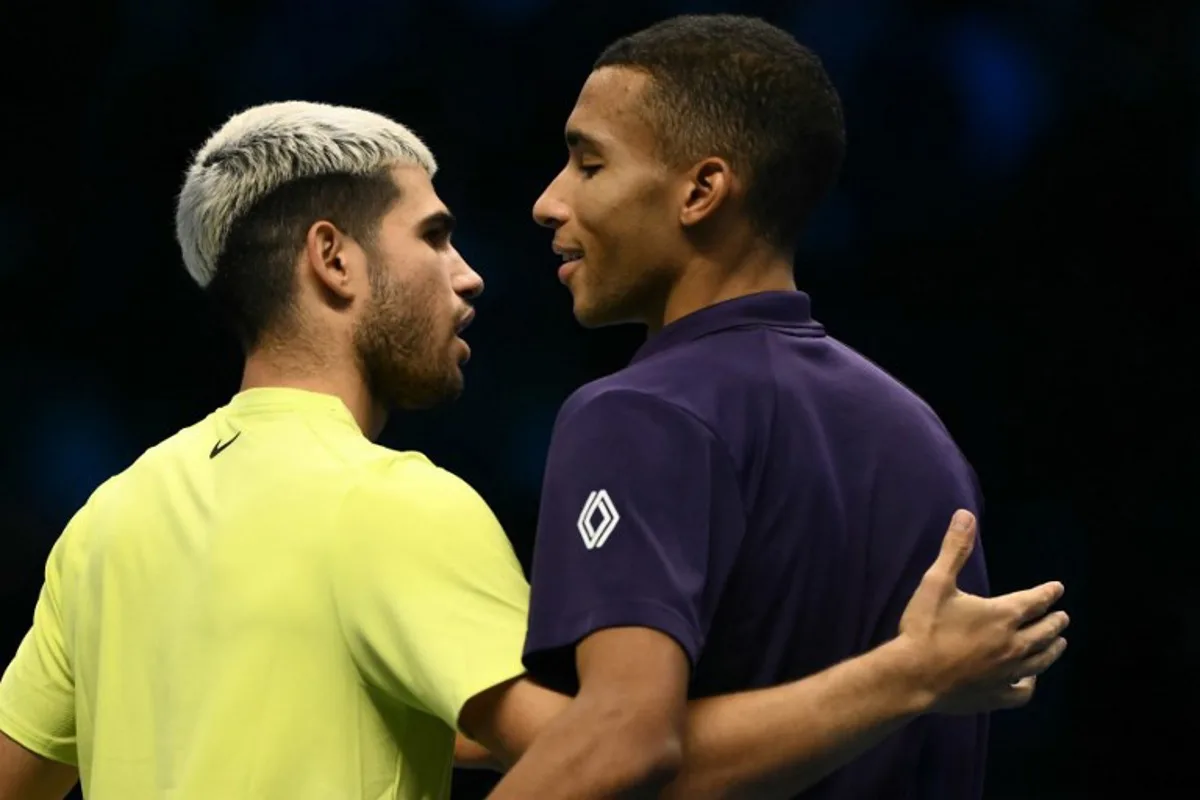 Spain's Carlos Alcaraz is congratulated by Canada's Felix Auger-Aliassime after winning the semifinal at the ATP Finals tennis tournament in Turin on November 15, 2025. Marco BERTORELLO / AFP