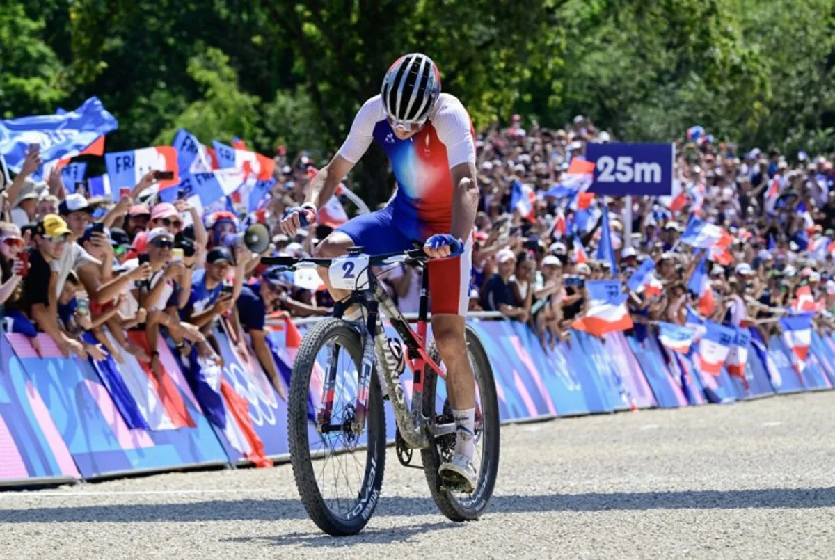 France's Victor Koretzky cycles to the finish line to take second place (silver medal)  in the men's cross-country mountain biking event during the Paris 2024 Olympic Games in Elancourt Hill venue in Elancourt, on July 29, 2024.  John MACDOUGALL / AFP