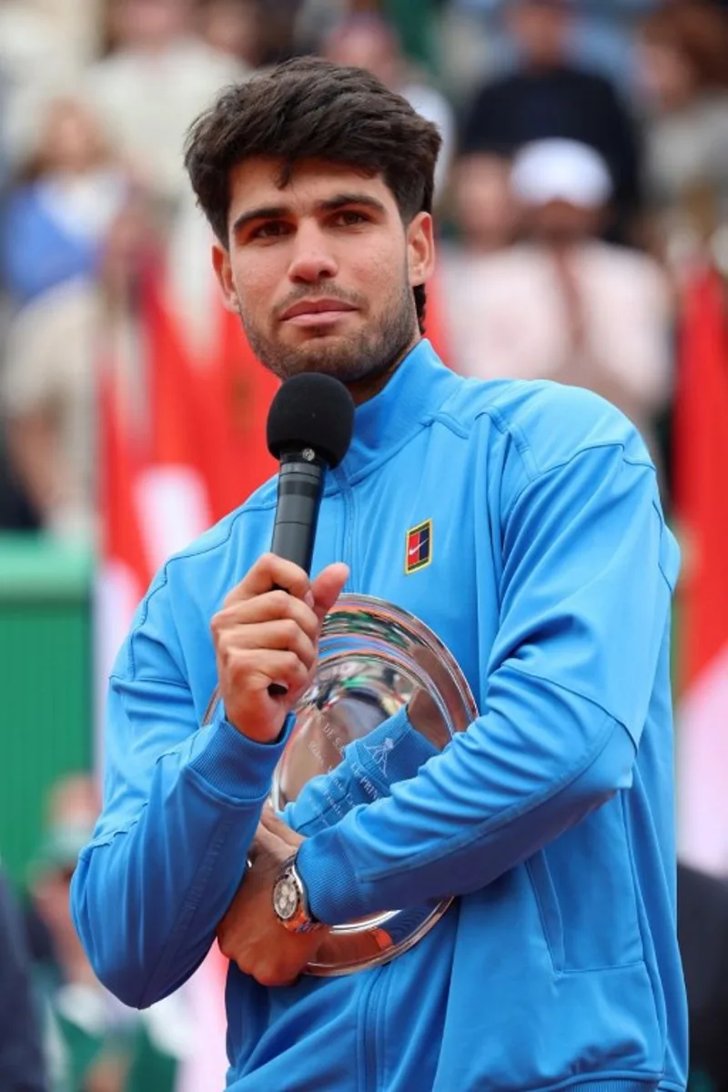Spain's Carlos Alcaraz delivers a speech as he celebrates second place on the podium after the Monte Carlo ATP Masters Series Tournament final tennis match against Italy's Jannik Sinner on Court Rainier III at the Monte-Carlo Country Club in Roquebrune-Cap-Martin, south-eastern France on April 12, 2026. Valery HACHE / AFP