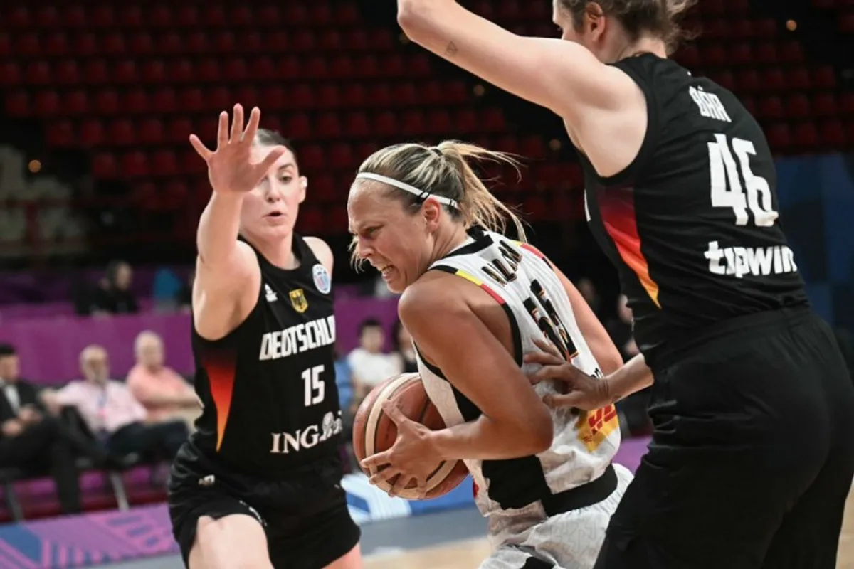 Belgium's point guard Julie Allemand (C) is defended by Germany's centre Luisa Geiselsoder (L) and Germany's small forward Romy Bar during the FIBA Women's EuroBasket 2025 quarter-final match between Belgium and Germany at the Peace and Friendship Stadium in Piraeus near Athens on June 25, 2025. Angelos Tzortzinis / AFP