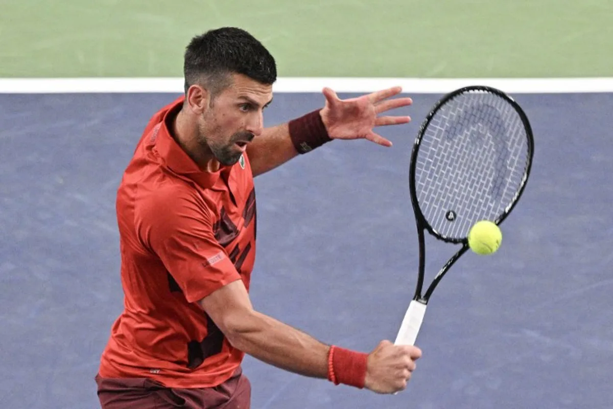 Serbia's Novak Djokovic hits a return to USA's Alex Michelsen during their men's singles match at the Shanghai Masters tennis tournament in Shanghai on October 5, 2024.  HECTOR RETAMAL / AFP