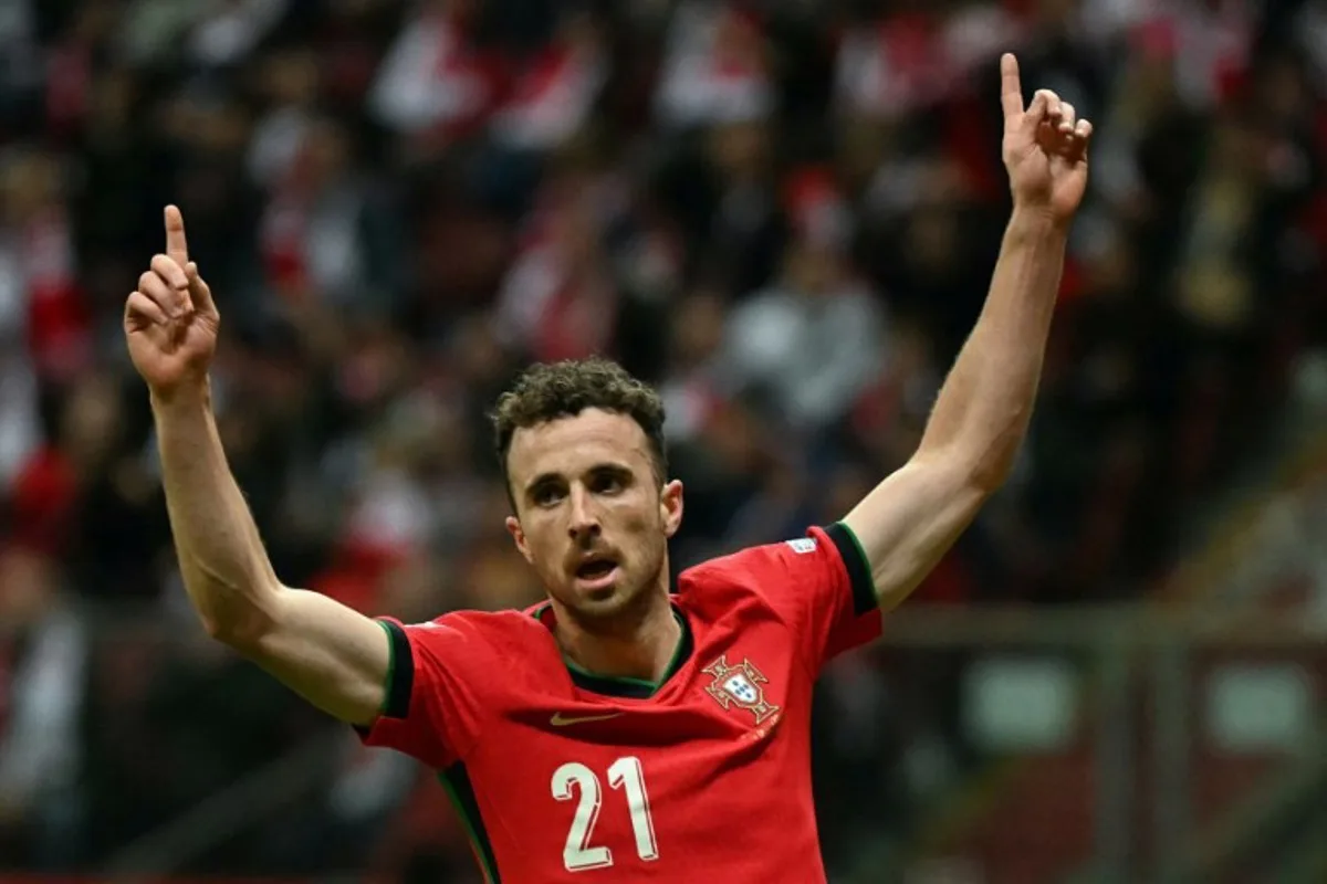 Portugal's forward #21 Diogo Jota reacts after Poland's defender #05 Jan Bednarek scored an own goal during the UEFA Nations League, League A Group A1 football match Poland vs Portugal at the National Stadium in Warsaw, Poland on October 12, 2024. Sergei GAPON / AFP