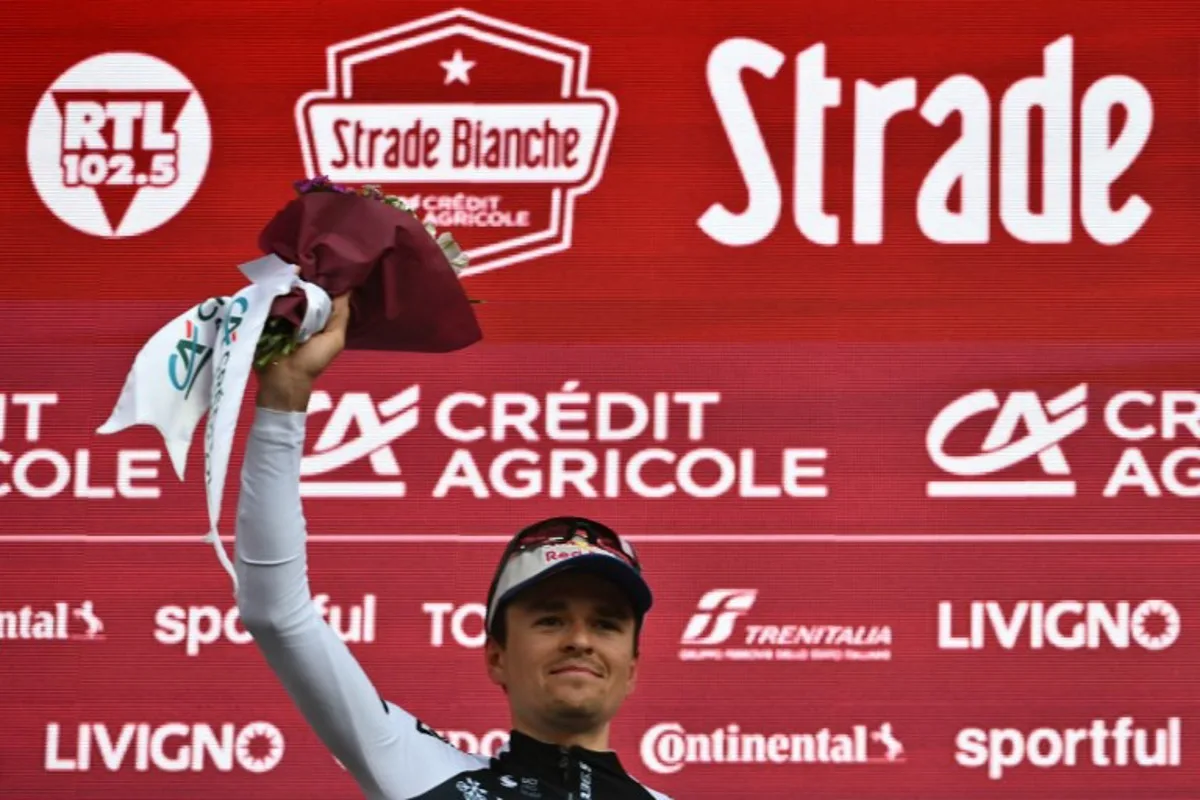 Second-placed Team Q36.5's British rider Thomas Pidcock celebrates on the podium of the 19th one-day classic 'Strade Bianche' (White Roads) men's cycling race between Siena and Siena in Tuscany on March 8, 2025.   Marco BERTORELLO / AFP