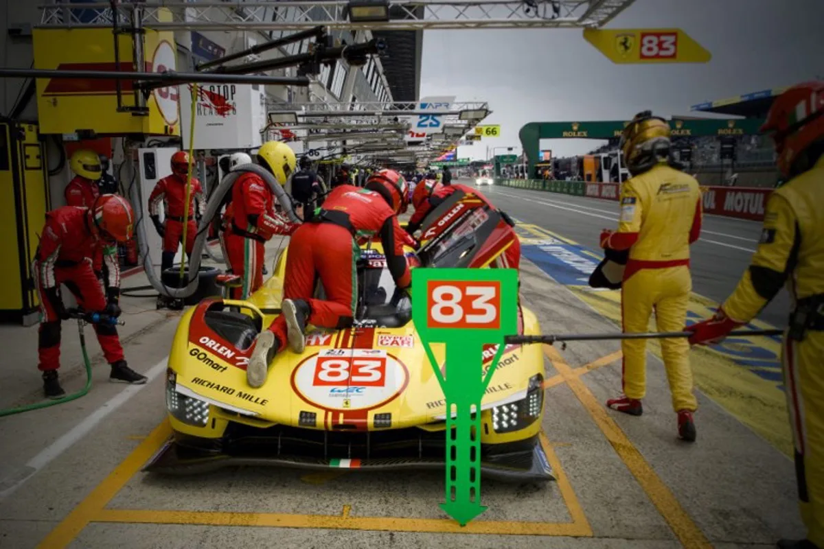 Mechanics prepare the Ferrari 499P number 83 on the pit lane during the warm up before the 24 Hours of Le Mans endurance race, which is part of the FIA World Endurance Championship (WEC), in Le Mans, Western France, on June 15, 2024.   GUILLAUME SOUVANT / AFP