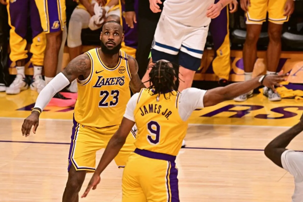 Los Angeles Lakers' US guard #09 Bronny James jumps to block a shot as Los Angeles Lakers' US small forward #23 LeBron James looks on during the NBA game season opener between the Los Angeles Lakers and the Minnesota Timberwolves at Crypto Arena in Los Angeles on October 22, 2024. LeBron and Bronny are the first father and son to play together in any NBA game. Frederic J. Brown / AFP