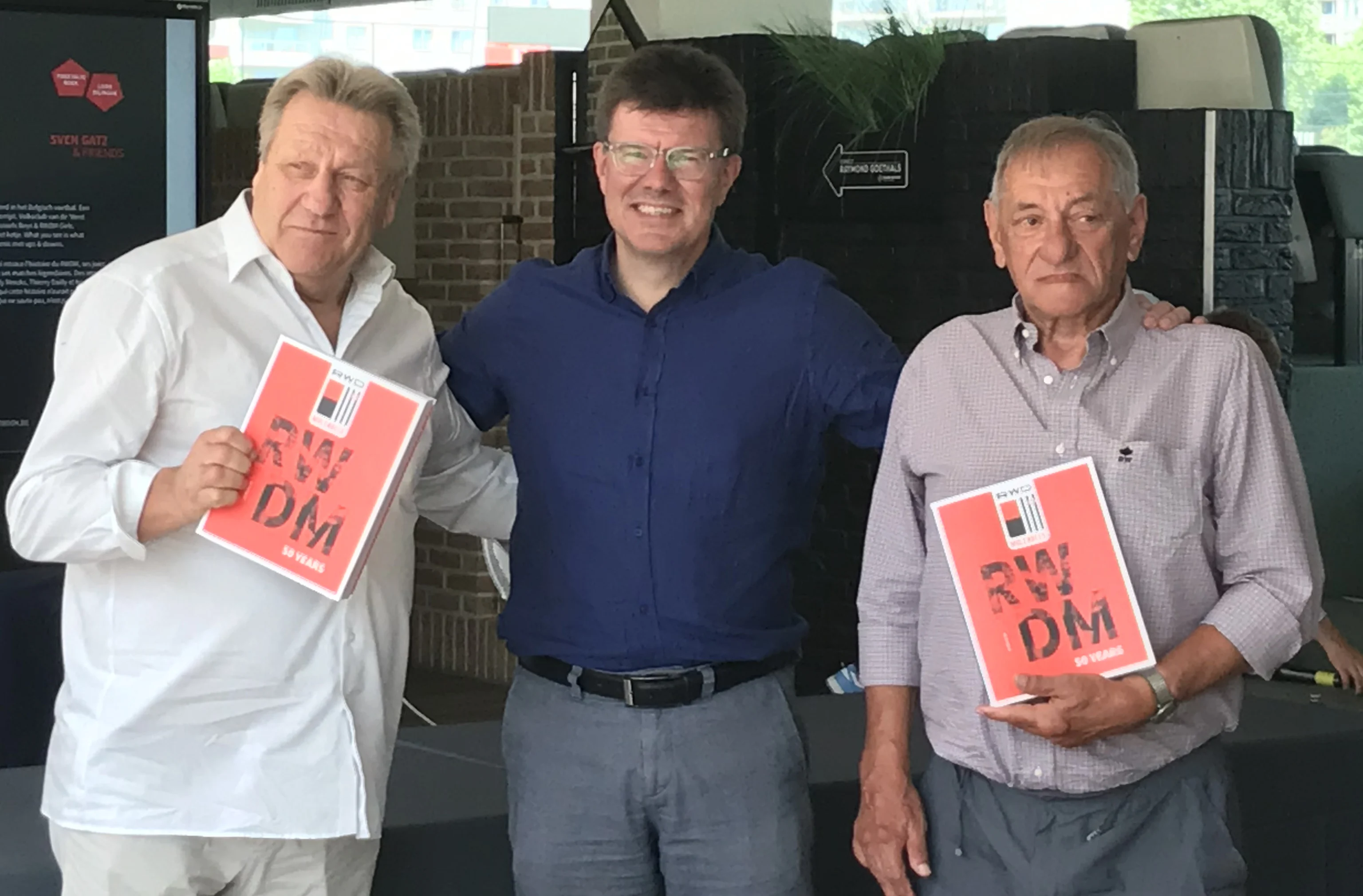 Former RWDM player Johan Boskamp, Brussels region Minister Sven Gatz, former RWDM player Jacques Teugels pose as Gatz presents his book 'RWDM 50 Years' on Brussels' soccer team RWDM, Wednesday 14 June 2023 in Brussels. BELGA PHOTO ADRIAN BURTIN