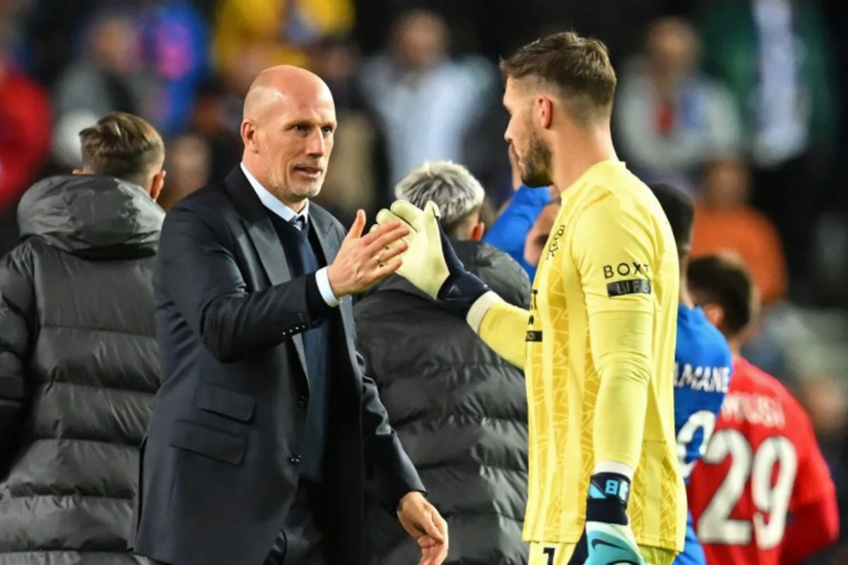 Rangers Belgian manager Philippe Clement (L) shakes hands with Rangers' English goalkeeper #01 Jack Butland (R) on the pitch after the UEFA Europa League, League stage day 3 football match between Rangers and FCSB at the Ibrox Stadium in Glasgow on October 24, 2024. Rangers won the game 4-0. ANDY BUCHANAN / AFP