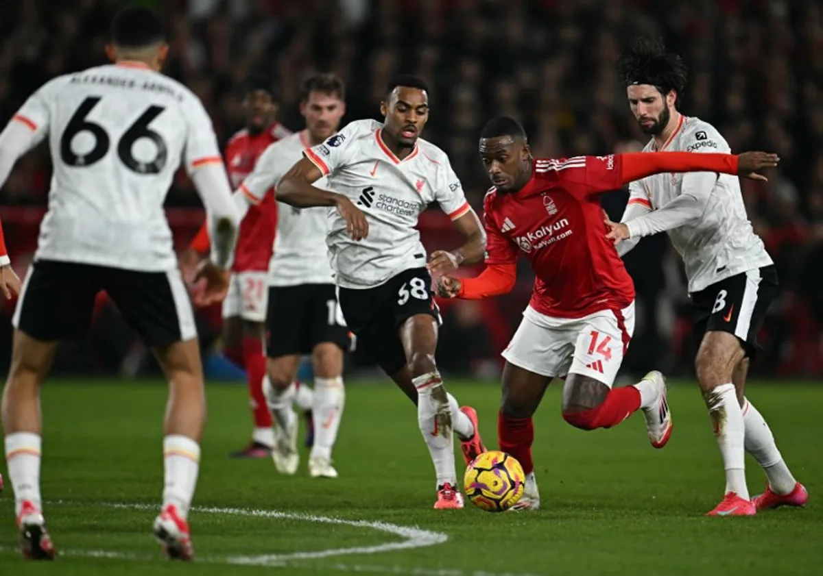 Liverpool's Hungarian midfielder #08 Dominik Szoboszlai (R) and Liverpool's Dutch midfielder #38 Ryan Gravenberch (C) vie with Nottingham Forest's English midfielder #14 Callum Hudson-Odoi during the English Premier League football match between Nottingham Forest and Liverpool at The City Ground in Nottingham, central England, on January 14, 2025.  Paul ELLIS / AFP