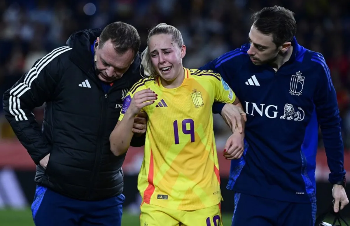 Belgium's defender #19 Saar Janssen is helped to leave the pitch after resulting injured during the UEFA Women's Nations League group A3 football match between Spain and Belgium at Ciutat de Valencia stadium in Valencia on February 21, 2025.  JOSE JORDAN / AFP