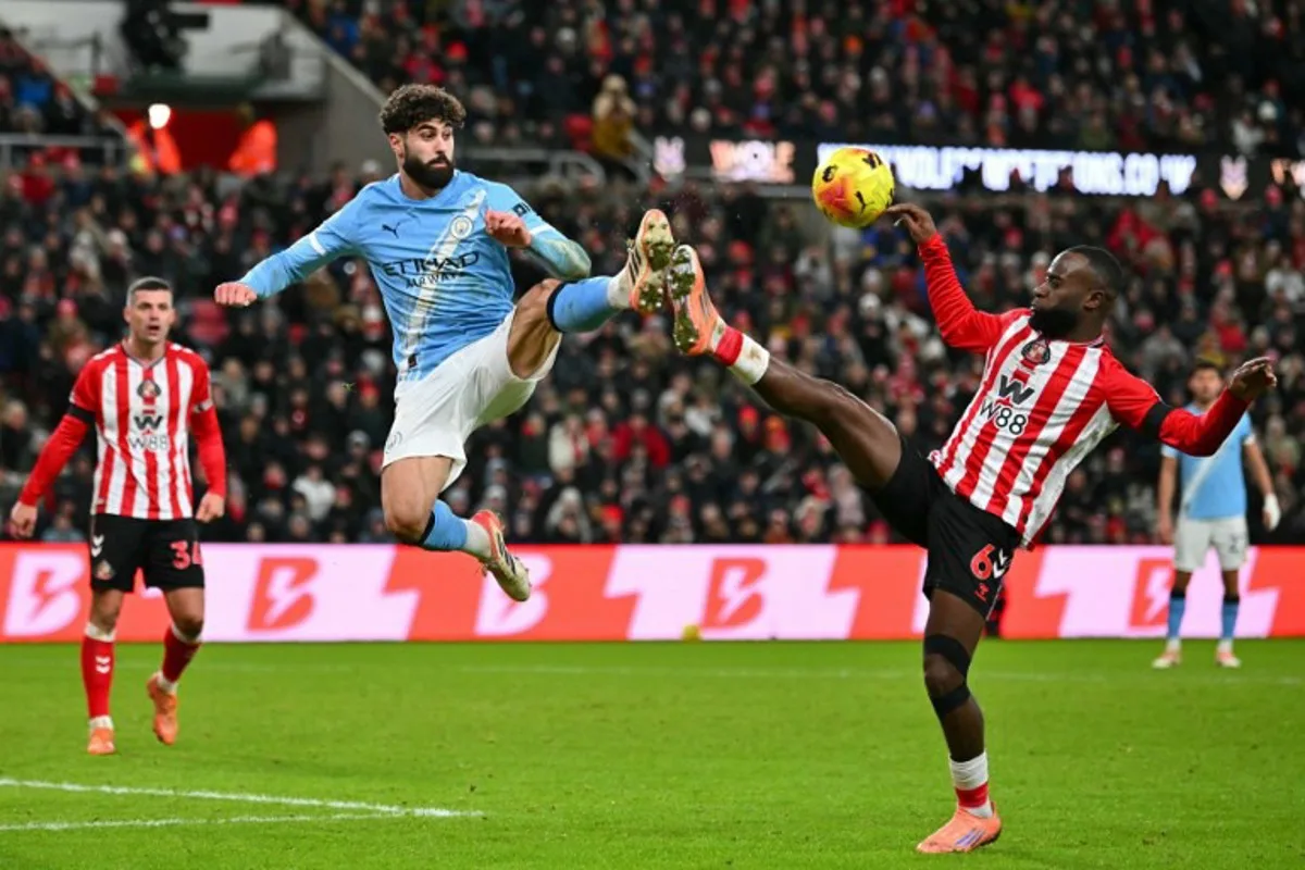 Manchester City's Croatian defender #24 Josko Gvardiol (C) leaps for a ball against Sunderland's Dutch defender #06 Lutsharel Geertruida (R) during the English Premier League football match between Sunderland and Manchester City at The Stadium of Light in Sunderland in north east England on January 1, 2026.  ANDY BUCHANAN / AFP