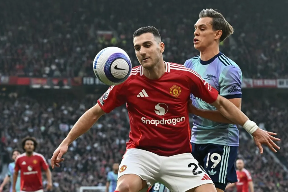 Manchester United's Portuguese defender #20 Diogo Dalot (L) vies with Arsenal's Belgian midfielder #19 Leandro Trossard (R) during the English Premier League football match between Manchester United and Arsenal at Old Trafford in Manchester, north west England, on March 9, 2025.  Paul ELLIS / AFP