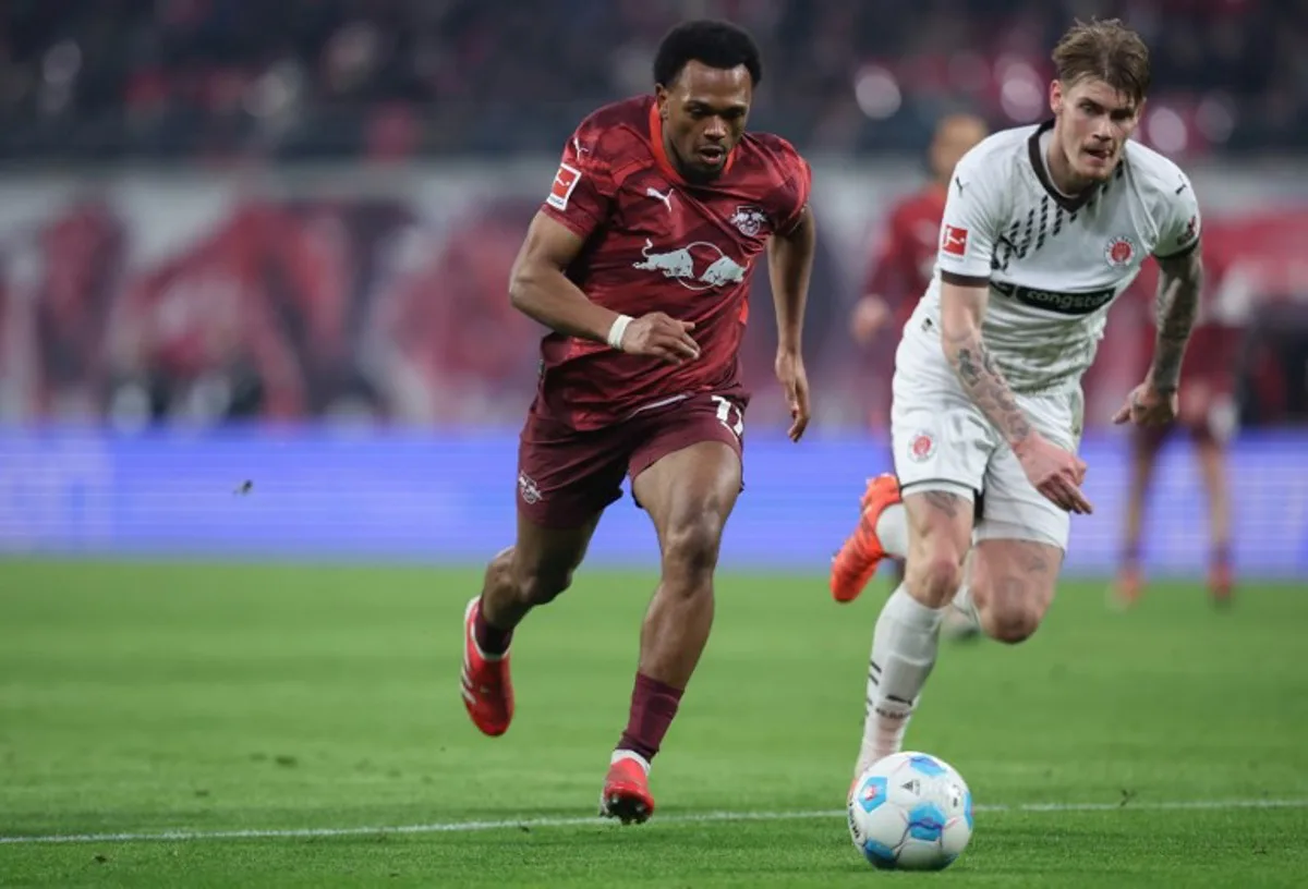 Leipzig's Belgian forward #11 Lois Openda (L) and St Pauli's Swedish defender #08 Eric Smith vie for the ball during the German first division Bundesliga football match RB Leipzig vs St Pauli in Leipzig, eastern Germany on February 9, 2025.  Ronny HARTMANN / AFP