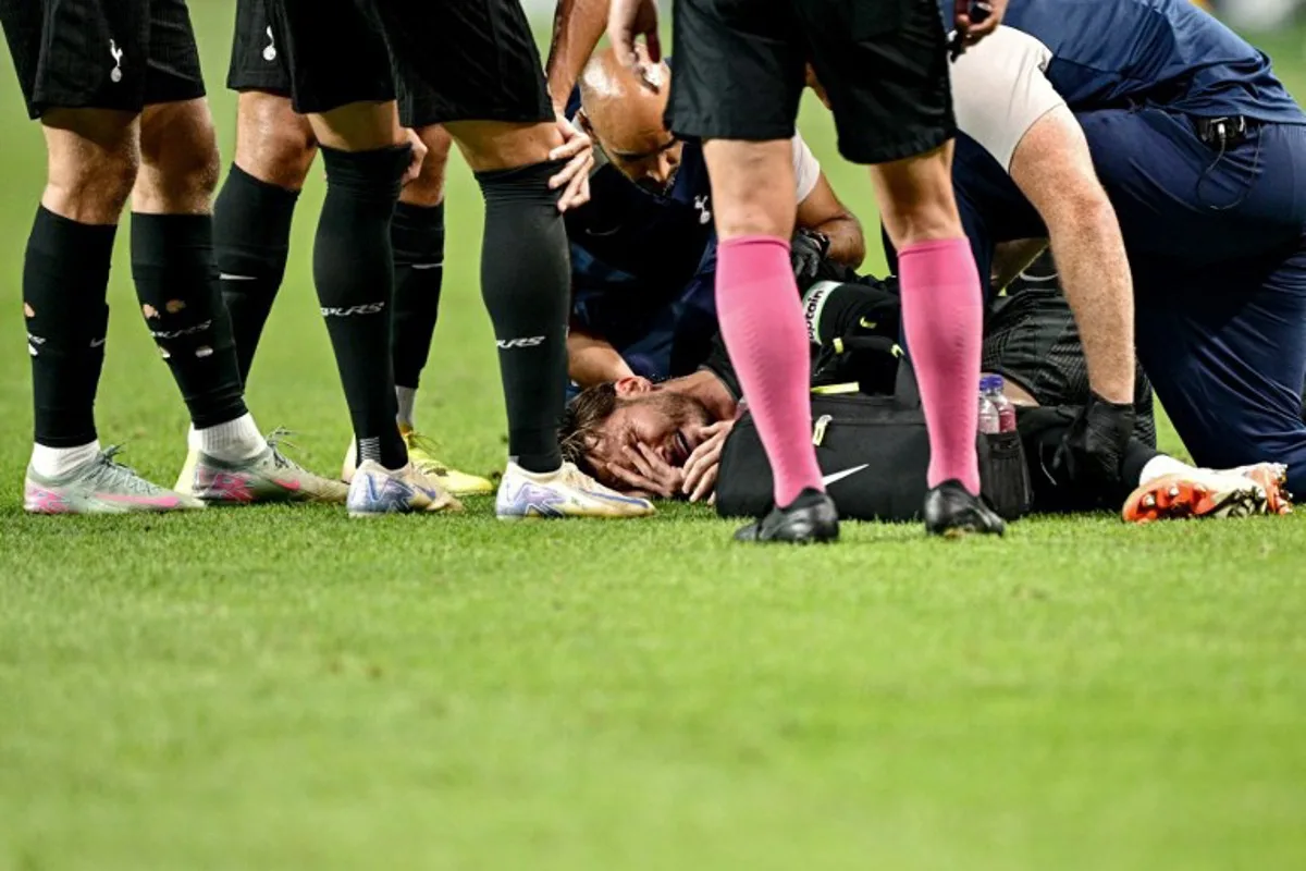 Tottenham Hotspur's James Maddison (C) reacts before being stretchered off the pitch, after suffering an injury during a friendly football match between Tottenham Hotspur and Newcastle United in Seoul on August 3, 2025. Anthony WALLACE / AFP