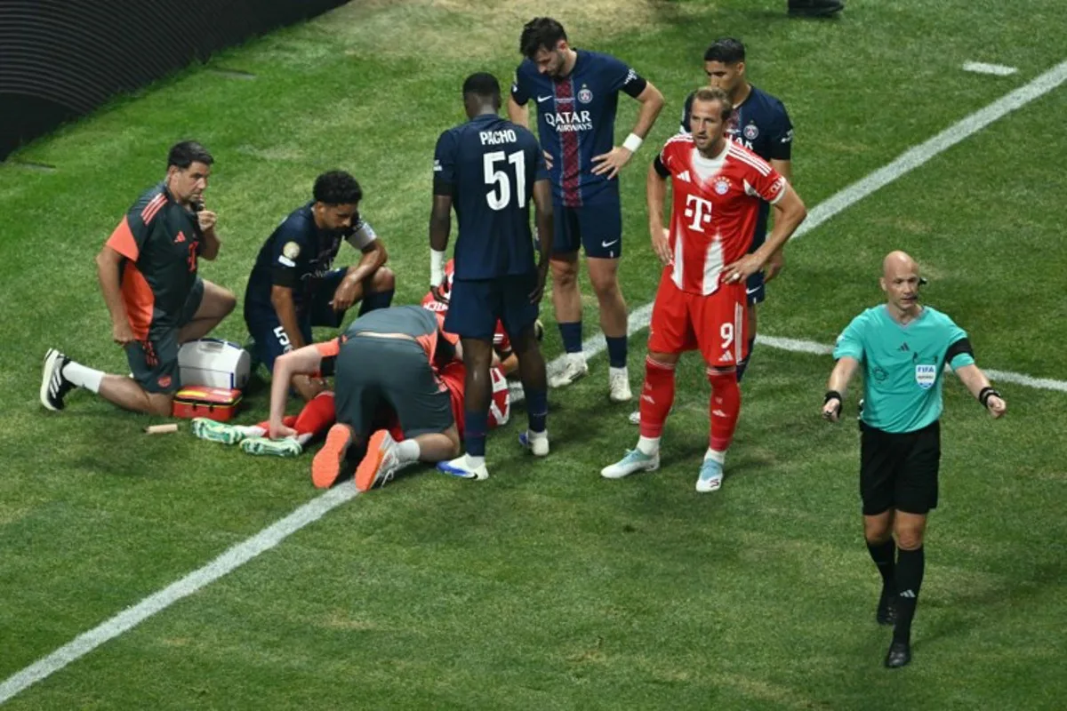 Paris Saint-Germain's players watch Bayern Munich's German midfielder #42 Jamal Musiala injured on the ground during the FIFA Club World Cup 2025 quarterfinal football match between France's Paris Saint-Germain and Germany's Bayern Munich at the Mercedes-Benz Stadium in Atlanta on July 5, 2025. ROBERTO SCHMIDT / AFP