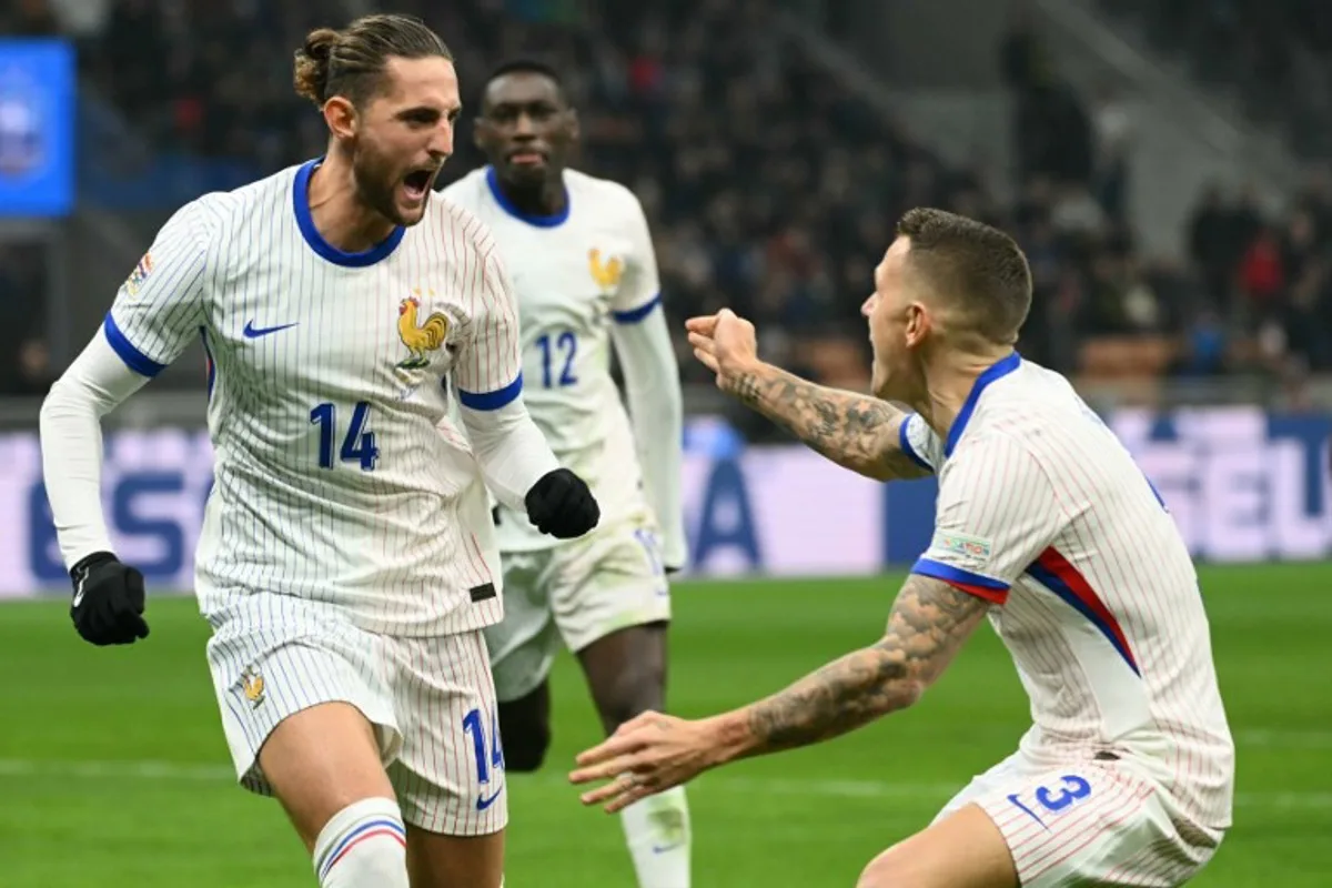 France's forward #14 Adrien Rabiot (L) celebrates with France's defender #03 Lucas Digne after scoring a goal during the Nations League group A2 football match between Italy and France at San Siro stadium in Milan, on November 17, 2024.  Alberto PIZZOLI / AFP