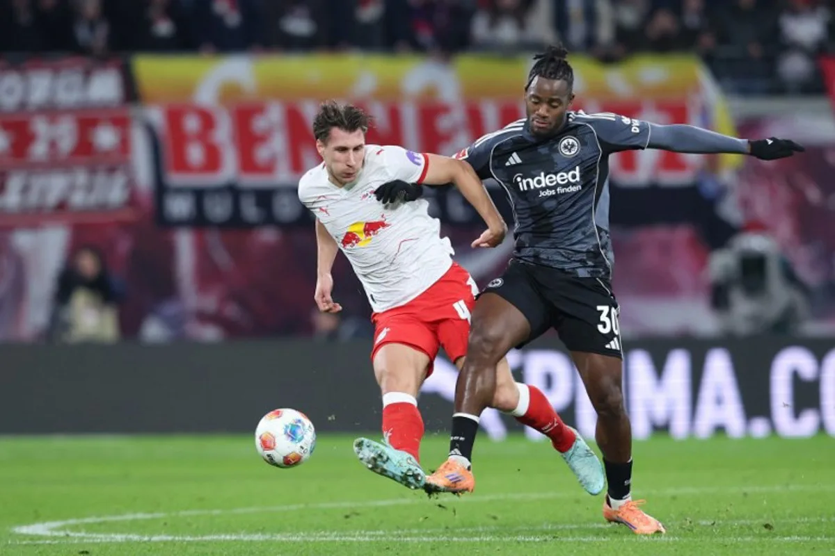 Leipzig's Hungarian defender #04 Willi Orban (L) and Frankfurt's Belgian forward #30 Michy Batshuayi vie for the ball during the German first division Bundesliga football match between RB Leipzig and Eintracht Frankfurt in Leipzig, eastern Germany, on December 6, 2025.  Ronny HARTMANN / AFP